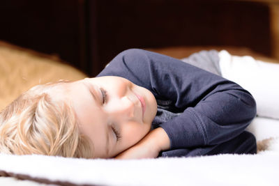 Portrait of baby boy sleeping on bed at home