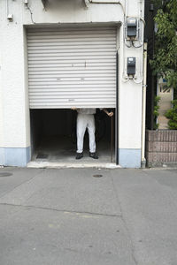 Full length of man standing on footpath against building