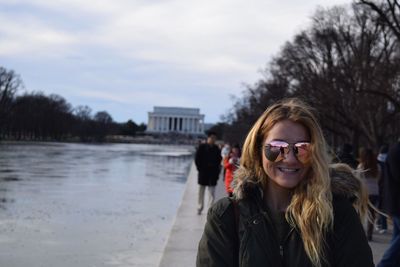 Portrait of young woman wearing sunglasses while standing at lincoln memorial