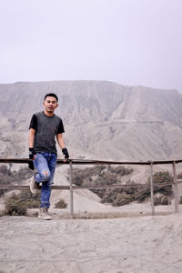 Rear view of man standing against mountain