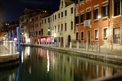 Reflection of buildings in canal at night