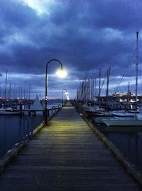 Pier on sea against cloudy sky