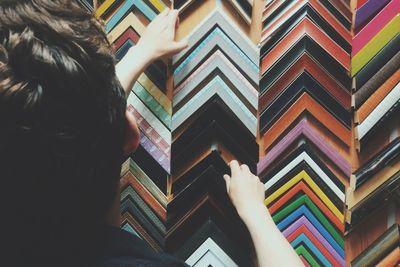 Rear view of man selecting picture frames in store