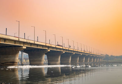 Road bridge with polluted river with industrial and domestic effluents toxic foam at sunrise
