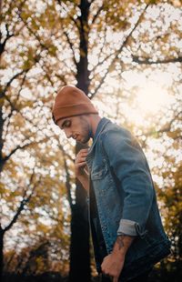 Low angle view of man standing by tree