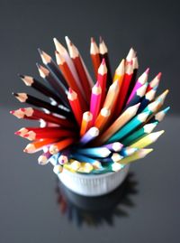 Close-up of multi colored pencils on table in case on table