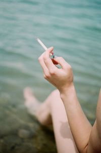 Midsection of woman holding cigarette