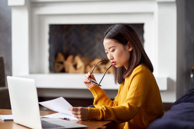 Businesswoman holding paper brainstorming whiles sitting in office