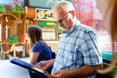 Man looking at camera while standing on mobile phone