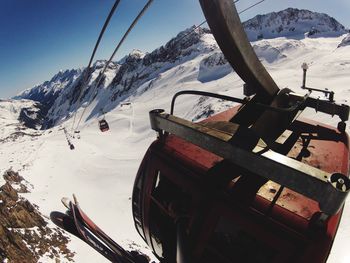 Overhead cable car over snowcapped mountains against sky