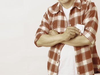 Midsection of man holding ice cream against white background