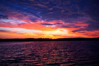 Scenic view of sea against dramatic sky during sunset