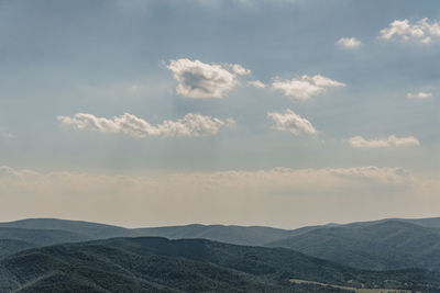 Scenic view of mountains against cloudy sky