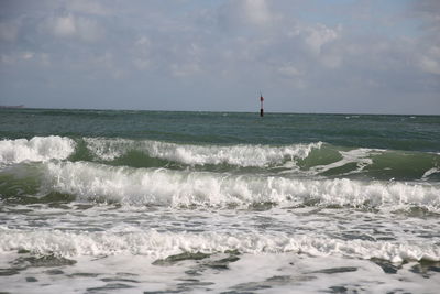 Scenic view of rough sea against sky