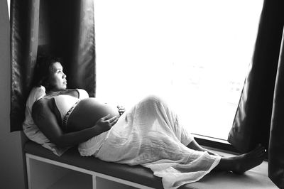 Pregnant woman sitting by window