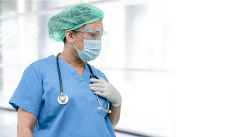 Female doctor standing against white background