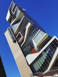 Low angle view of modern buildings against clear blue sky