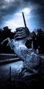 Statue in water against sky