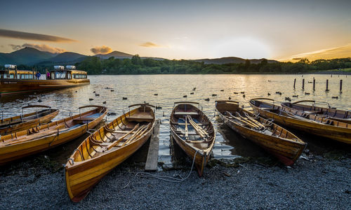Boats on beach at sunset