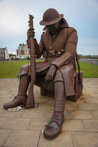 Full length of man sitting on seat against sky