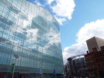 Low angle view of buildings against cloudy sky