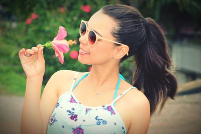 Close-up of young woman wearing sunglasses standing outdoors