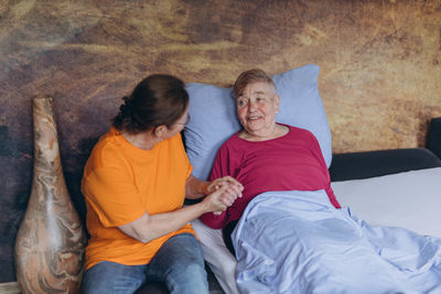 Portrait of young woman sitting on bed at home