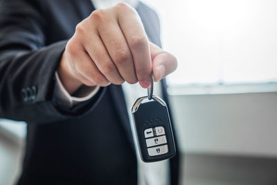 Midsection of insurance agent holding car key 