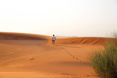 Man walking on sand dune