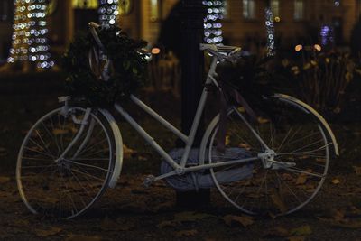 Bicycle parked on street in city at night