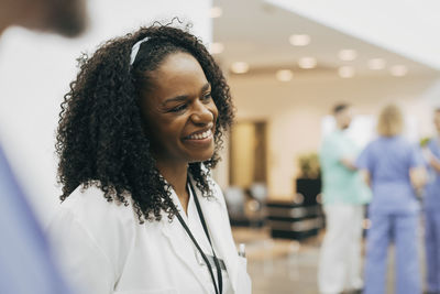 Happy female doctor with curly hair at hospital