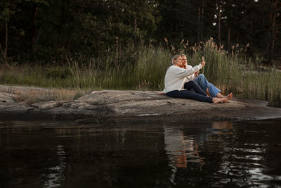 Female couple sitting at lake