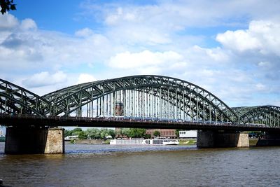 Arch bridge over river against sky