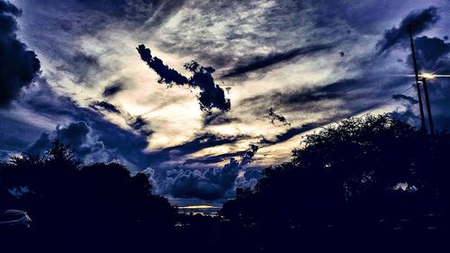 Low angle view of silhouette trees against sky