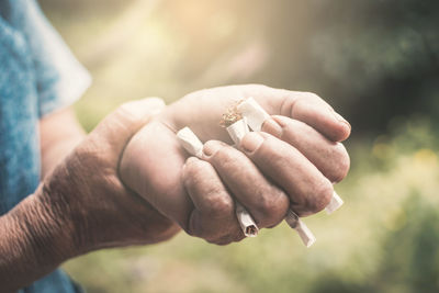 Cropped image of hand crushing cigarettes