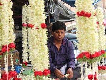 Portrait of vendor selling floral garlands at market