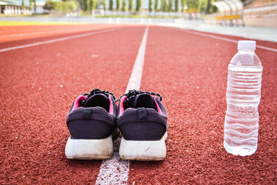 Shoes and water bottle on running track
