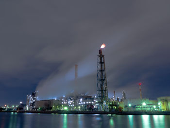 Night view of an oil refinery covered in steam.