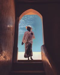 Rear view of man standing by window