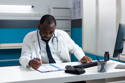 Doctor using laptop while sitting at hospital