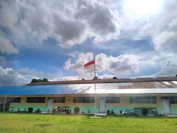 Built structure on grassy field against sky