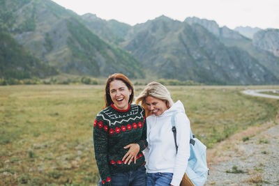 Portrait of a smiling young woman standing on mountain