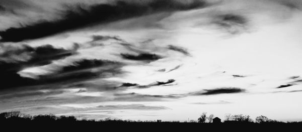 Low angle view of silhouette trees against sky