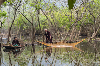 Rear view of woman kayaking in lake