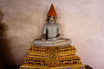 Statue of buddha against wall in building