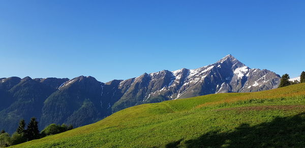 Scenic view of snowcapped mountains against clear blue sky