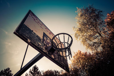 Low angle view of basketball hoop against sky during sunset