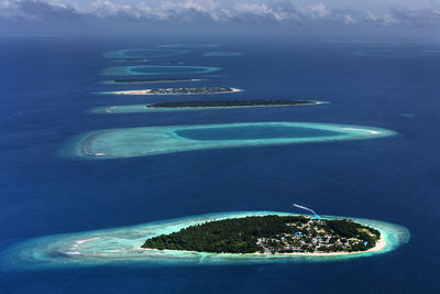 Aerial view from seaplane window house and building over atolls and island at indian ocean, maldives