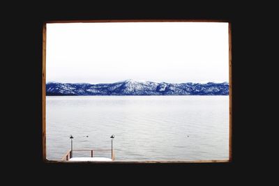 Scenic view of sea against clear sky seen through window