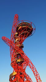 Low angle view of ferris wheel against clear blue sky